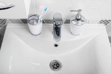 Bathroom, body care products and towel. Bath preparation. White interior of bathroom. Shampoo, shower gel and other bathing accessories. Toothbrush and soap dispenser. details of bathroom interior
