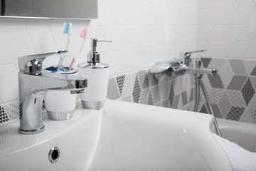 Bathroom, body care products and towel. Bath preparation. White interior of bathroom. Shampoo, shower gel and other bathing accessories. Toothbrush and soap dispenser. details of bathroom interior