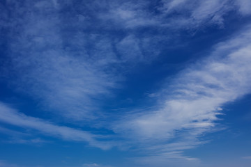 A deep blue sky with light white clouds background