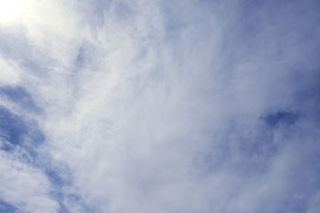 A deep blue sky with light white clouds background