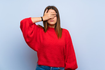 Young woman over isolated blue wall covering eyes by hands. Do not want to see something