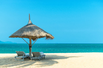 Idyllic landscape paradise scene at the beach with parasol on clear blue sky day