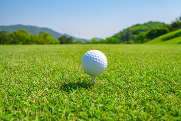 Golf Course with Golf Ball on tee. Golf course with a rich green turf beautiful scenery.