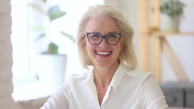 Confident mature businesswoman in glasses looking at camera, video portrait