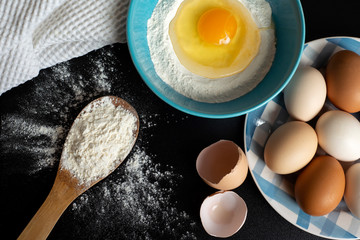 Preparation of the dough. Flour, eggs and a kitchen towel. A bunch of flour on a wooden spoon, a...