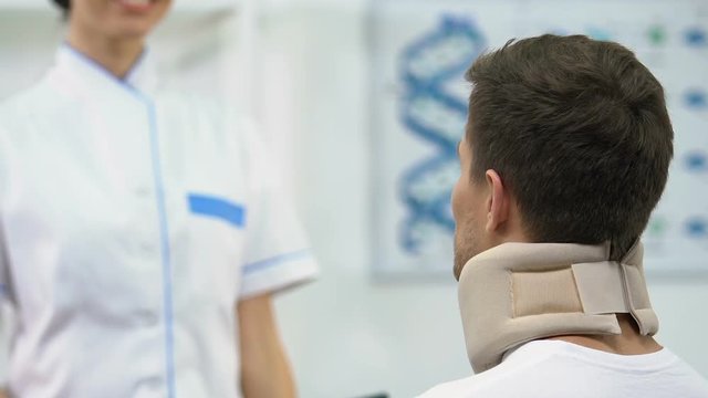 Female doctor informing man in foam cervical collar positive x-ray result