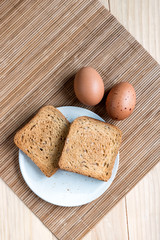 Two Slices of Toast Bread and and Two Boiled Eggs on a Wooden Table Setup