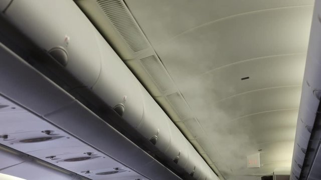 Aircraft cabin with smoke-like air vapor condensation due to differences of temperature between cabin and outside