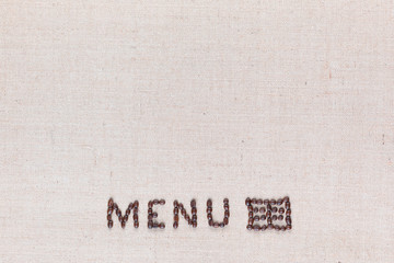 Menu word with icon made from roasted coffee beans on linen creamy linen canvas, shot from above, aligned bottom center.