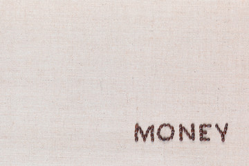 Money written with coffee beans on linen texture, arranged bottom right.