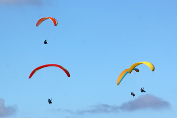 paragliders in a blue sky
