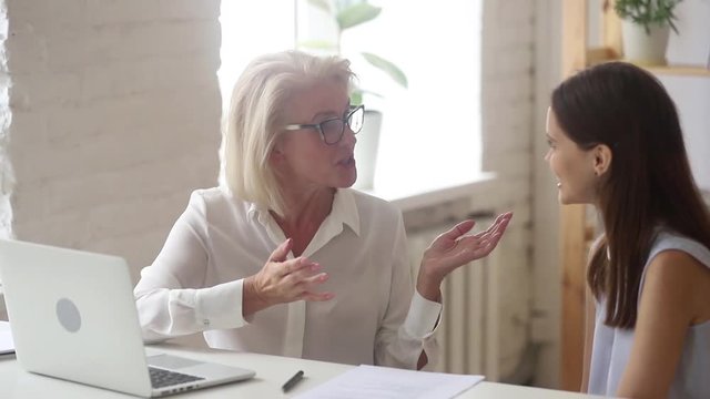Friendly old manager teacher mentor consulting young client student intern