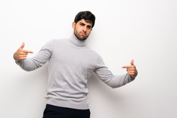 Fototapeta premium Young man over isolated white wall proud and self-satisfied