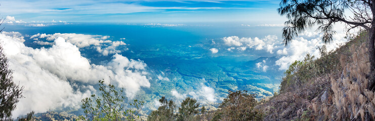 Panoramic view from a height. Panoramic view of the hills of the volcano Agung. Blue sky panorama with clouds