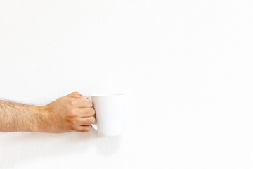 白いマグカップを持つ男性の手