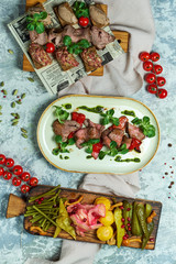 Cold meat snacks with pickled vegetables. Beautiful serving of dishes. Light gray background. Restaurant menu