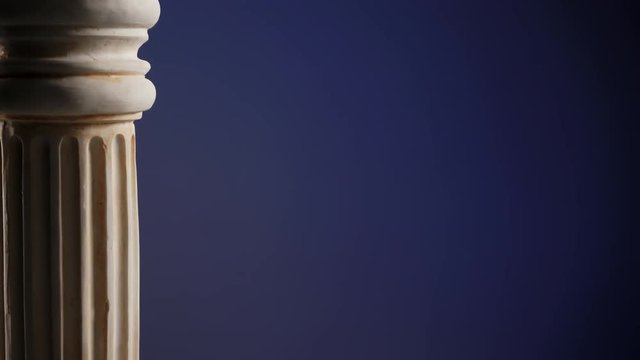 Single ancient greek column rotating slowly on color background, copy space text area