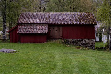 Historic, traditional red barn on a grey spring day in Lund, Norway