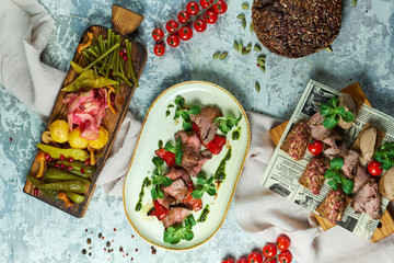 Cold meat snacks with pickled vegetables. Beautiful serving of dishes. Light gray background. Restaurant menu