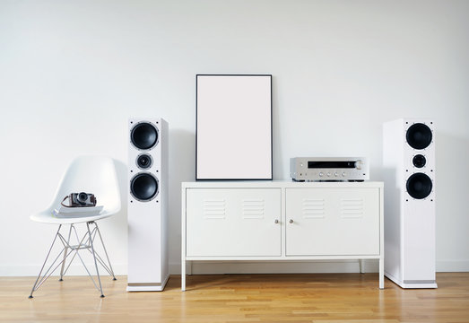 Poster Frame Mockup in white modern interior. Modern audio stereo system with white speakers on bureau in modern interior.