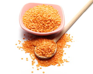 Red lentils with bowl  and wooden spoon isolated on white