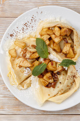 pancakes with apple and raisins on a plate top view