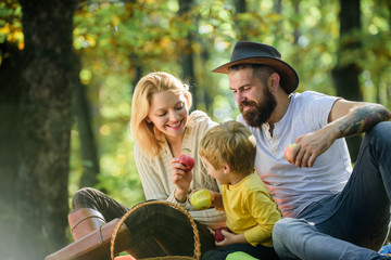 Mother father and little son sit forest picnic. Good day for spring picnic in nature. United with nature. Family day concept. Happy family with kid boy relaxing while hiking in forest. Family weekend