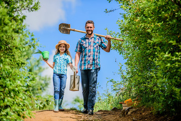 Spring gardening checklist. Father and daughter with shovel and watering can. It is time to plant prepare beds and care for lawn. Pick out flats favorite plants. Gardening pro tips. Spring gardening