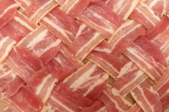 Raw bacon slices arranged into a lattice shape shot from above with macro lens