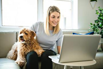 woman with his Golden Labradoodle dog at home