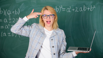 Woman tired or annoyed holds laptop. Educator smart clever lady with modern laptop hold gun gesture...