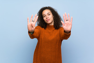 Dominican woman with curly hair counting nine with fingers