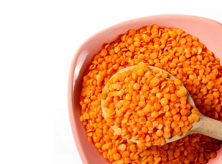 Red lentils with bowl  and wooden spoon isolated on white, top view