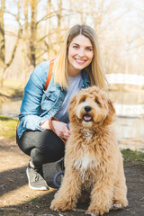 Happy Labradoodle Dog and woman outside at the park