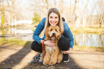 Happy Labradoodle Dog and woman outside at the park