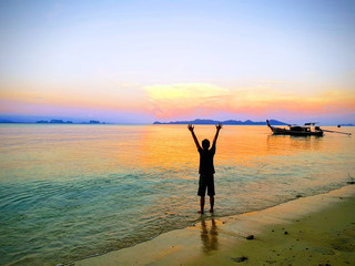 beautiful  sunrise of beach and young man reaching up at Koh Kradan Island, South of Thailand.Andaman