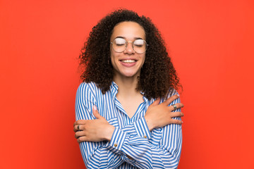 Dominican woman over red wall hugging