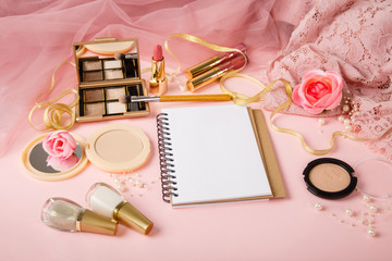 Obraz na płótnie Canvas Woman's cosmetics and diary. Nail polish, powder on romantic pink tulle background. Women's secrets, list of wishes. Pink and golden colors. Decorative cosmetics. Planning of shopping. Beauty secrets