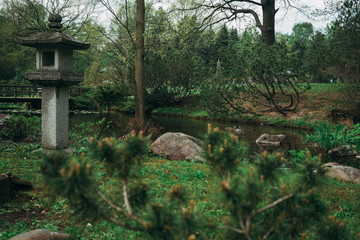 Stone lantern in a Japanese garden with lake