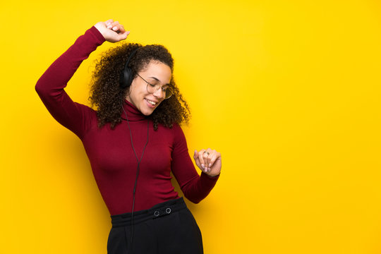 Dominican Woman With Turtleneck Sweater Listening To Music With Headphones And Dancing