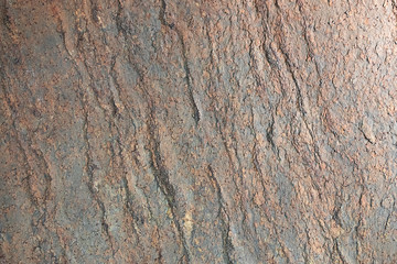 Natural stone, rusty texture embossed. The wall is made of stone, the surface is textured, red, rusty color.