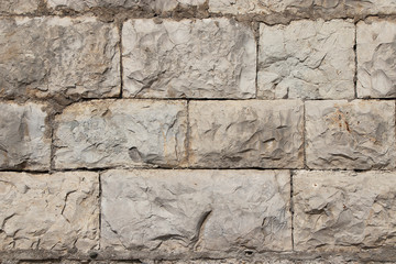 Stone natural wall in blocks. The texture of the stone block-lined wall of natural yellowing stone.