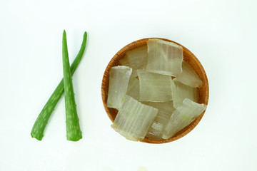 Fresh aloe vera gel on wooden cups and aloe vera leaves isolated on a white background.