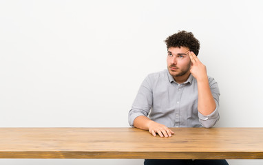 Fototapeta premium Young man with a table with problems making suicide gesture
