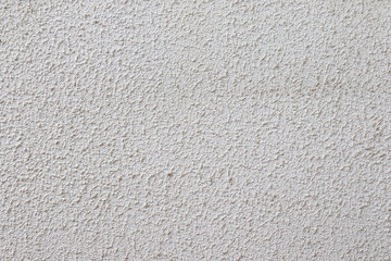 Light textured plaster on the wall. The wall is rough without seams modern decor cream.