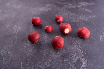 Red ripe reddish without leaves on blue textured surface, top view. Healthy diet and nutrition composition.