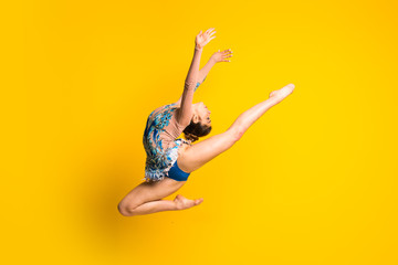 Girl doing rhythmic gymnastics jumping - obrazy, fototapety, plakaty