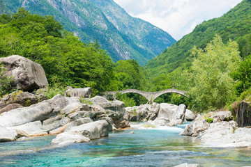 River in Valley Verzasca and Bridge Ponte dei Salti with Mountain in a Sunny Day in Ticino, Switzerland.