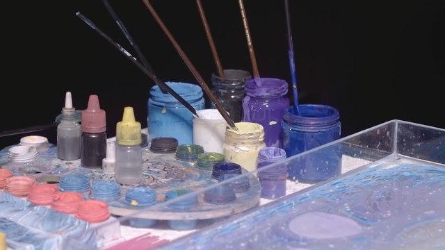 Artist creates absractive ebru design with blue and violet paints