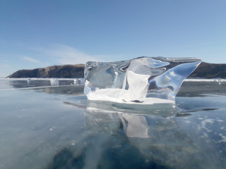 the sun's rays are refracted in crystal clear pieces of ice. winter landscape. Lake Baikal